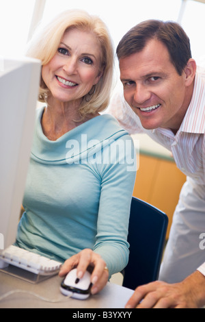 L uomo e la donna al computer sorridente (high key) Foto Stock