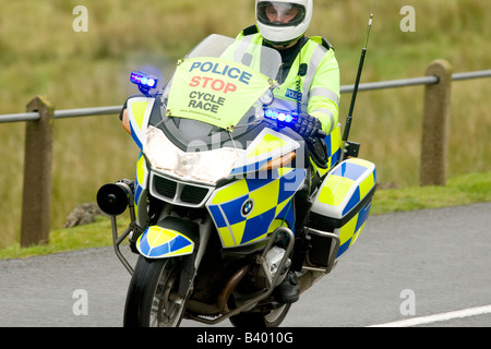 Moto polizia stradale motociclista con luci lampeggianti scortare il tour della Gran Bretagna gara ciclistica su strada rurale REGNO UNITO Foto Stock