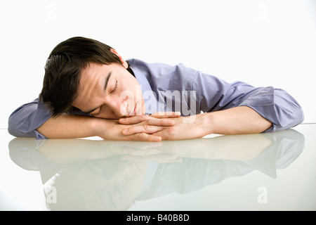 Imprenditore asiatico di dormire sulla scrivania in ufficio Foto Stock