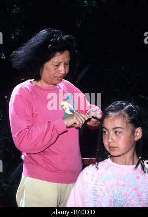 Asian madre trecce di capelli figlie Foto Stock