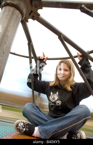 Giovane ragazza a cavallo su un merry-go-round, sfocatura del movimento Foto Stock