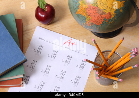 Istruzione scolastica ancora in vita con globo libri apple matite e una carta con un grado Foto Stock