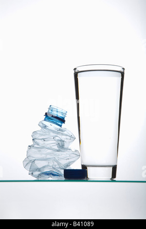 Riempito bicchiere da un swatted bottiglia di plastica Foto Stock
