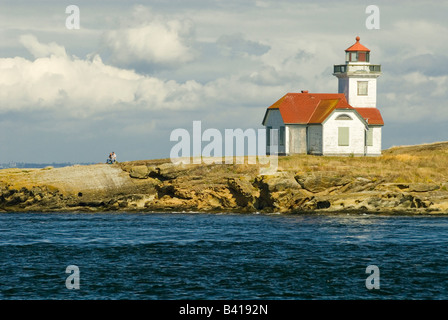 Stati Uniti d'America, WA, le Isole San Juan. Giovane attende il tramonto sul punto più settentrionale degli Stati Uniti continentali a Patos Island Lighthouse Foto Stock