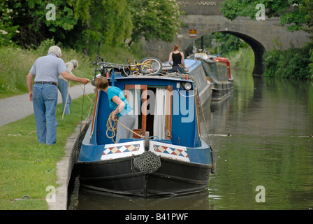 Persone su case galleggianti lungo argine, narrowboats, sentiero, Kennet and Avon Canal, bagno, Somerset, Inghilterra, Regno Unito Foto Stock