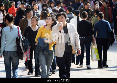 Coppia giovane a piedi su Via Wangfujing, Pechino, Cina Foto Stock