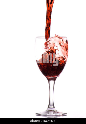 Un tiro dinamico di vino che viene versato nel bicchiere Foto Stock
