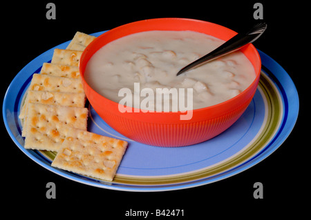 Un recipiente per la cottura a vapore di clam chowder con cracker isolate su nero Foto Stock