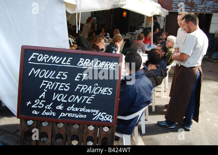 I camerieri che servono gli scommettitori di mangiare moules a Braderie Lille Francia Foto Stock