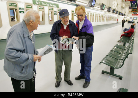 Gli uomini di consultare il modulo di corse a Suffolk Downs a Boston Foto Stock