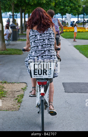 La donna a cavallo lungo il mare su un noleggio gratuito bicicletta fornita da Neuchatel Roule. Foto Stock