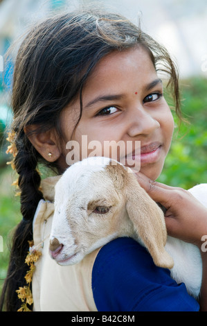 Ragazza indiana tenendo un giovane capretto. Andhra Pradesh, India Foto Stock