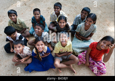 Gruppo di villaggio indiano bambini seduti a ridere divertendosi in India Foto Stock