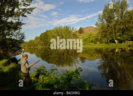 Un uomo getta la sua rete come lui pesca dei granchi sul fiume Duero nella città di Soria Spagna Foto Stock