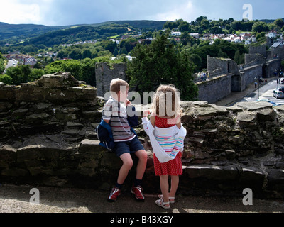Due bambini sulle mura di Conwy Castle, guardando la città murata. Un sito del patrimonio mondiale. Foto Stock
