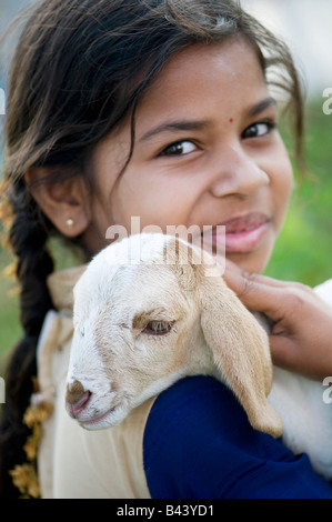 Ragazza indiana tenendo un giovane capretto. Andhra Pradesh, India Foto Stock