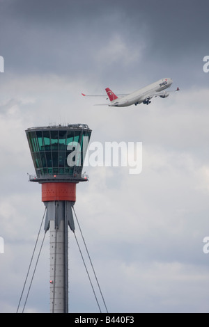 Northwest Airlines Airbus A330 di decollare in background di Londra Heathrow torre di controllo. Foto Stock