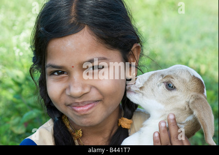 Ragazza indiana tenendo un giovane capretto. Andhra Pradesh, India Foto Stock