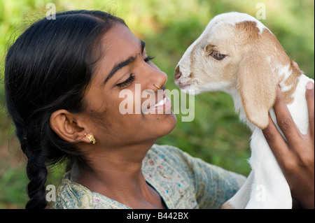 Ragazza indiana tenendo un giovane capretto. Andhra Pradesh, India Foto Stock