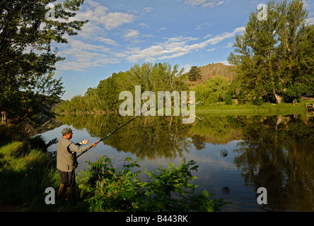 Un uomo getta la sua rete come lui pesca dei granchi sul fiume Duero nella città di Soria Spagna Foto Stock