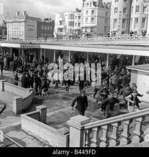 La cultura giovanile Mod Mods Swinging Sixties Mods di raccolta a Brighton run riot lungo il mare come si riuniscono tutti nella Sussex Foto Stock