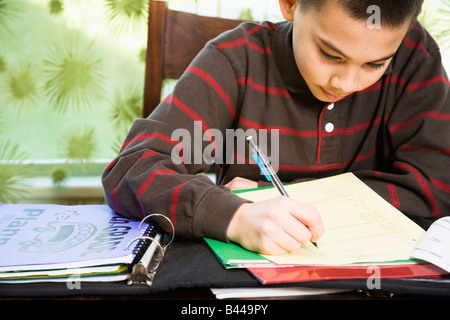 Ragazzo asiatico svolgendo compiti Foto Stock