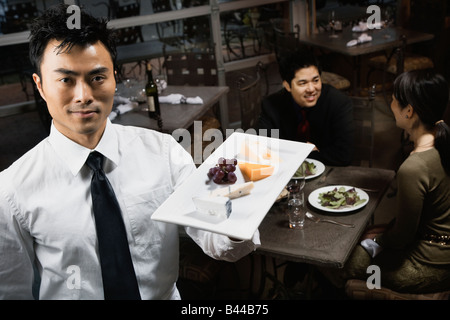 Asian cameriere piastra portante di cibo Foto Stock