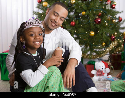 African padre e figlia di fronte ad albero di Natale Foto Stock