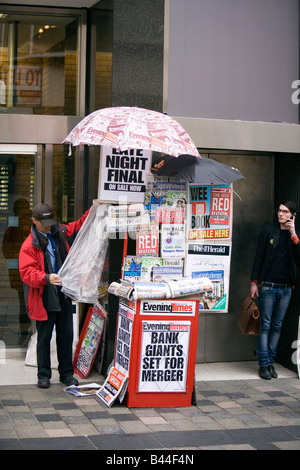 Regno Unito Scozia Glasgow Sauchiehall Street news fornitori in stallo sotto ombrello di carta da giornale Foto Stock