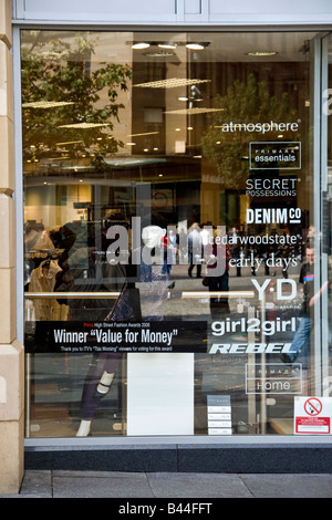 Le riflessioni e gli annunci pubblicitari sulla finestra di Primark fashion outlet a Dundee, Regno Unito Foto Stock