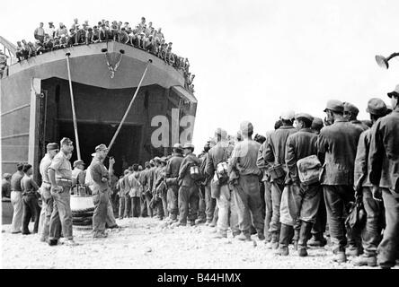 I marinai americani guarda tedesco POWs mongola a bordo di una landing craft durante il WW2 1944 Foto Stock