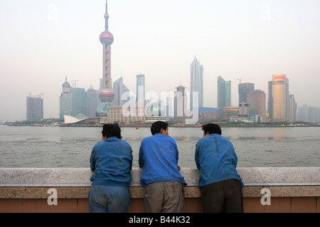 Tre uomini guardando il Cityscape di Pudong di Shanghai, Cina Foto Stock