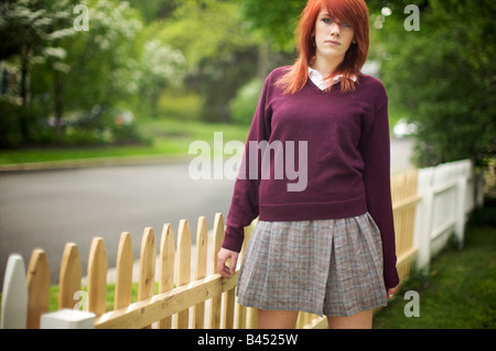 Ribelle quindicenne schoolgirl in uniforme agisce sempre in modo maturo e fiducioso dal paradiso dei suoi genitori di cortile anteriore Foto Stock