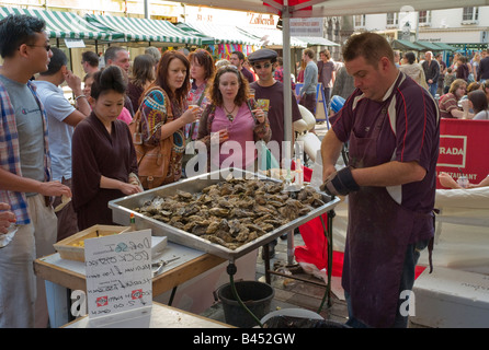 I clienti in attesa di essere serviti con ostriche fresche all'aperto di stallo di frutti di mare, Brighton, Inghilterra Foto Stock