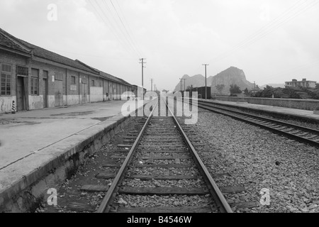 Piccolo centro rurale deposito dei treni in sottosviluppato a sudovest di Guangxi con montagne nel lontano orizzonte Foto Stock