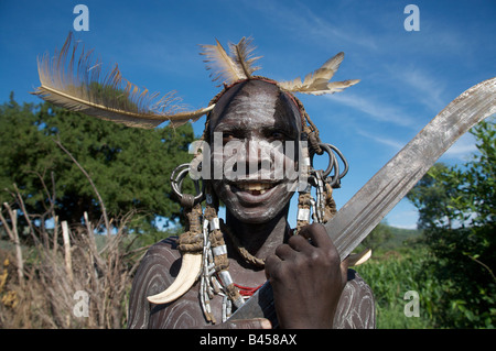 Un uomo della tribù dei Mursi detiene un machete, parco nazionale di mago, l'Etiopia meridionale, Africa orientale Foto Stock