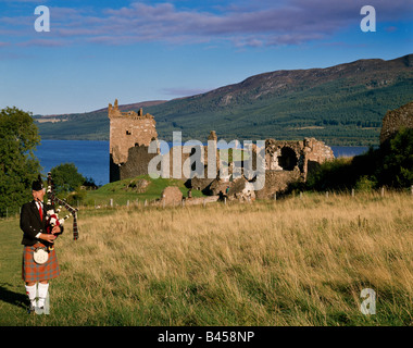 Il castello di Urquhart e suonatore di cornamusa scozzese Loch Ness Highland Regione Scozia UK Foto Stock