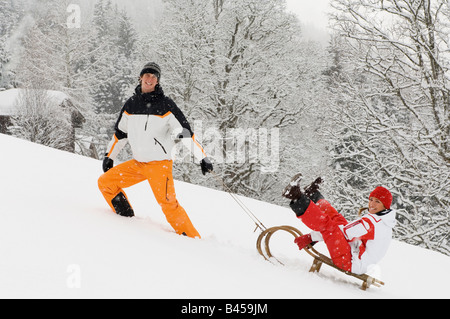 Austria, Salzburger Land, Altenmarkt-Zauchensee, giovane donna di trazione sulla slitta Foto Stock