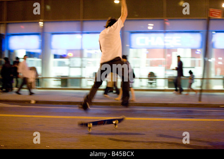 Guidatore di skateboard rendendo trucchi sulla strada di New York Astor Place Manhattan NY USA Foto Stock