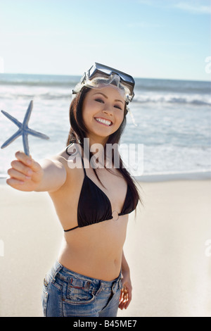 Donna asiatica holding starfish Foto Stock