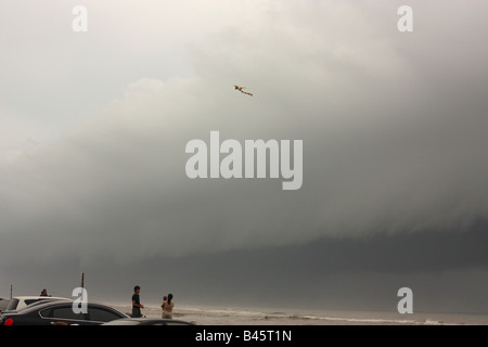 Una persona volare un aquilone come una tempesta di approcci anteriore. Foto Stock