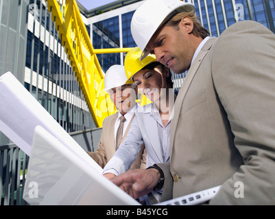 Germania, Baden Württemberg, Stoccarda, uomo e donna nel duro cappelli guardando il blueprint Foto Stock