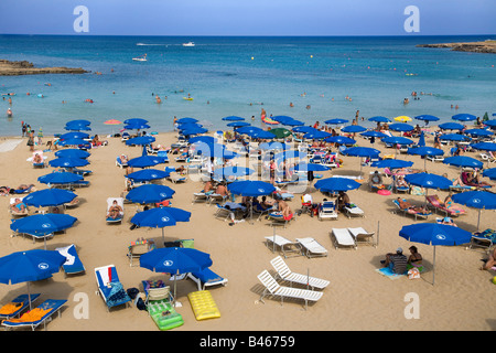 Vista di Fig Tree Bay, Protaras, a Cipro con molti ombrelloni blu e sabbia dorata Foto Stock