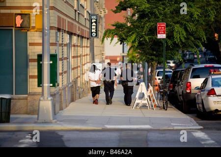 Due poliziotti scortare ammanettato criminale alla Brooklyn notti qua Corte Brooklyn NY USA Foto Stock