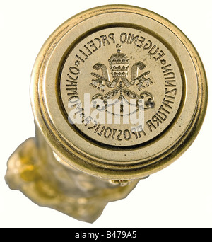Papa Pio XII - un sigillo personale, come Nunzio Apostolico a Monaco. Il manico in bronzo placcato oro ha la forma di un ragazzo in una camicia lunga, aperta al petto con il cuore di Gesù. La superficie di tenuta in bronzo inavvitabile è incisa con l'emblema della Nunziatur apostolica - la tiara papale sulle chiavi incrociate - e l'iscrizione circostante 'Eugenio Pacelli - Nunziatura Apostolica Monaco'. Altezza 10 cm. Ci sono anche foto di A. Baromini (cardinale?) con autografo, von Lingg (vescovo di Augsburg), un certo numero di biglietti da visita, tra cui tre per 'monsieur E. Pacel, Foto Stock