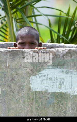 Ragazzo indiano nascosto in un calcestruzzo rurale vasca di lavaggio. India Foto Stock