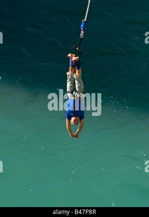 Un bungee uomo che si avvicina all'acqua dal ponte A J Hackett sul fiume Kawarau a Queenstown, South Island, nuova Zelanda Foto Stock