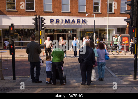 Le persone che attraversano la strada di attraversamento pedonale fuori Primark in Norwich, Norfolk, Regno Unito Foto Stock