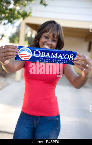African American teenager holding Obama campagna presidenziale di adesivo e sorridente Foto Stock