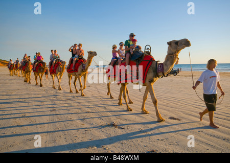 I treni di cammelli che trasportano i turisti sulla spiaggia di Cable Broome Australia Occidentale Foto Stock